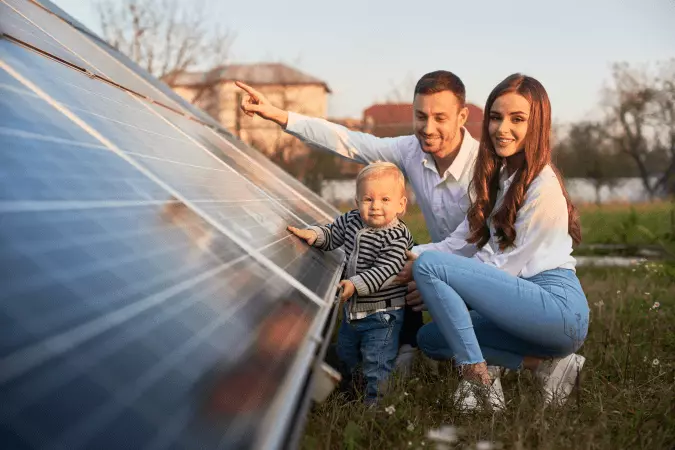 un enfant et se parents à côté de pannes solaires